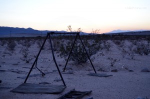 Old rusty swing set in the desert sunset